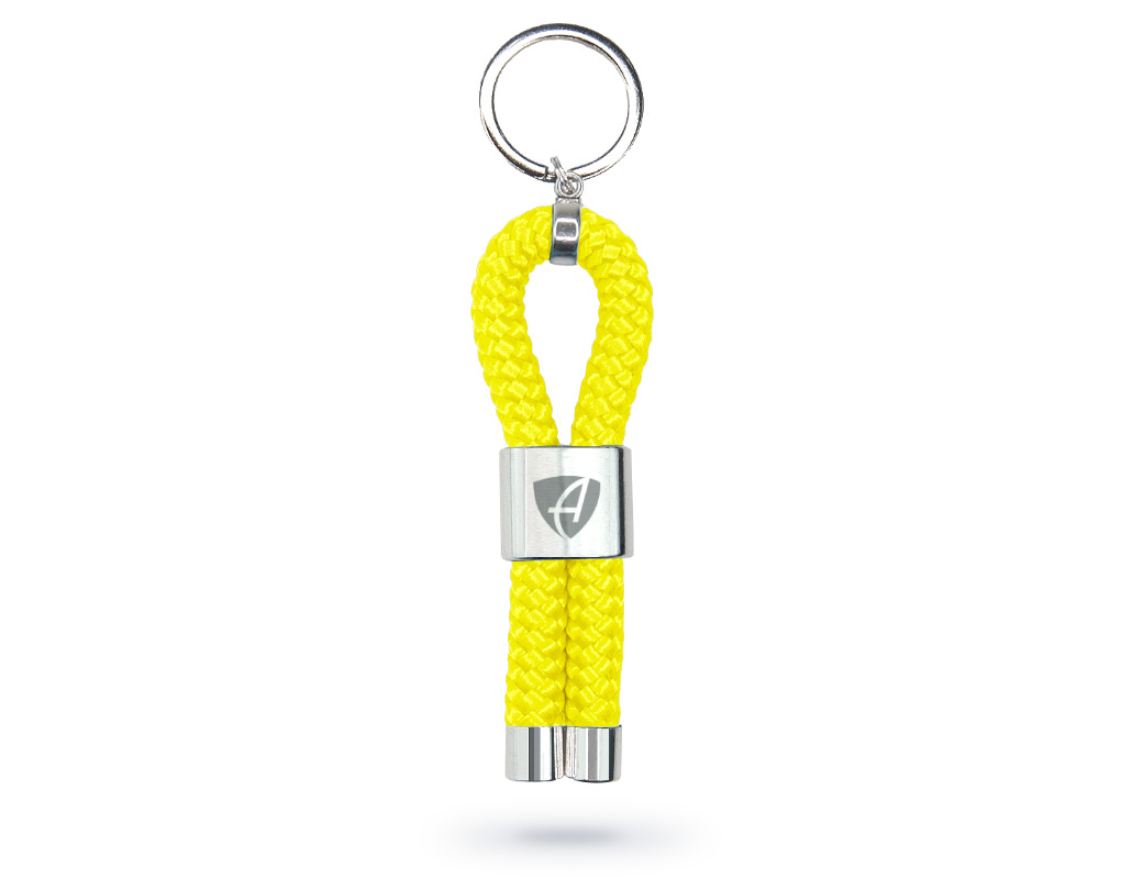Vorderansicht eines lime-gelben CB Ammersee Schlüsselanhänger mit silberner Schelle und Gravur des Ammersee Logos der Modemarke AMMERSEE BAVARIA aus Bayern, Deutschland