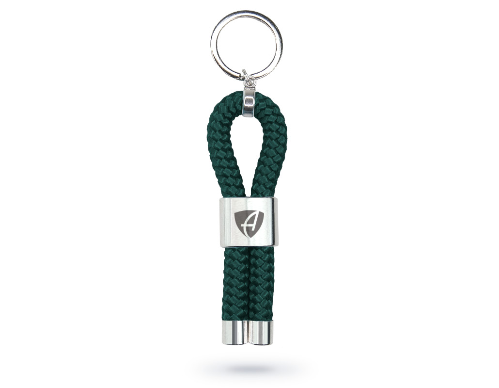 Vorderansicht eines waldgrünen CB Ammersee Schlüsselanhänger mit silberner Schelle und Gravur des Ammersee Logos der Modemarke AMMERSEE BAVARIA aus Bayern, Deutschland